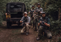 Four MilSim airsoft players beside a Land Rover at The Kingdom, Staffordshire